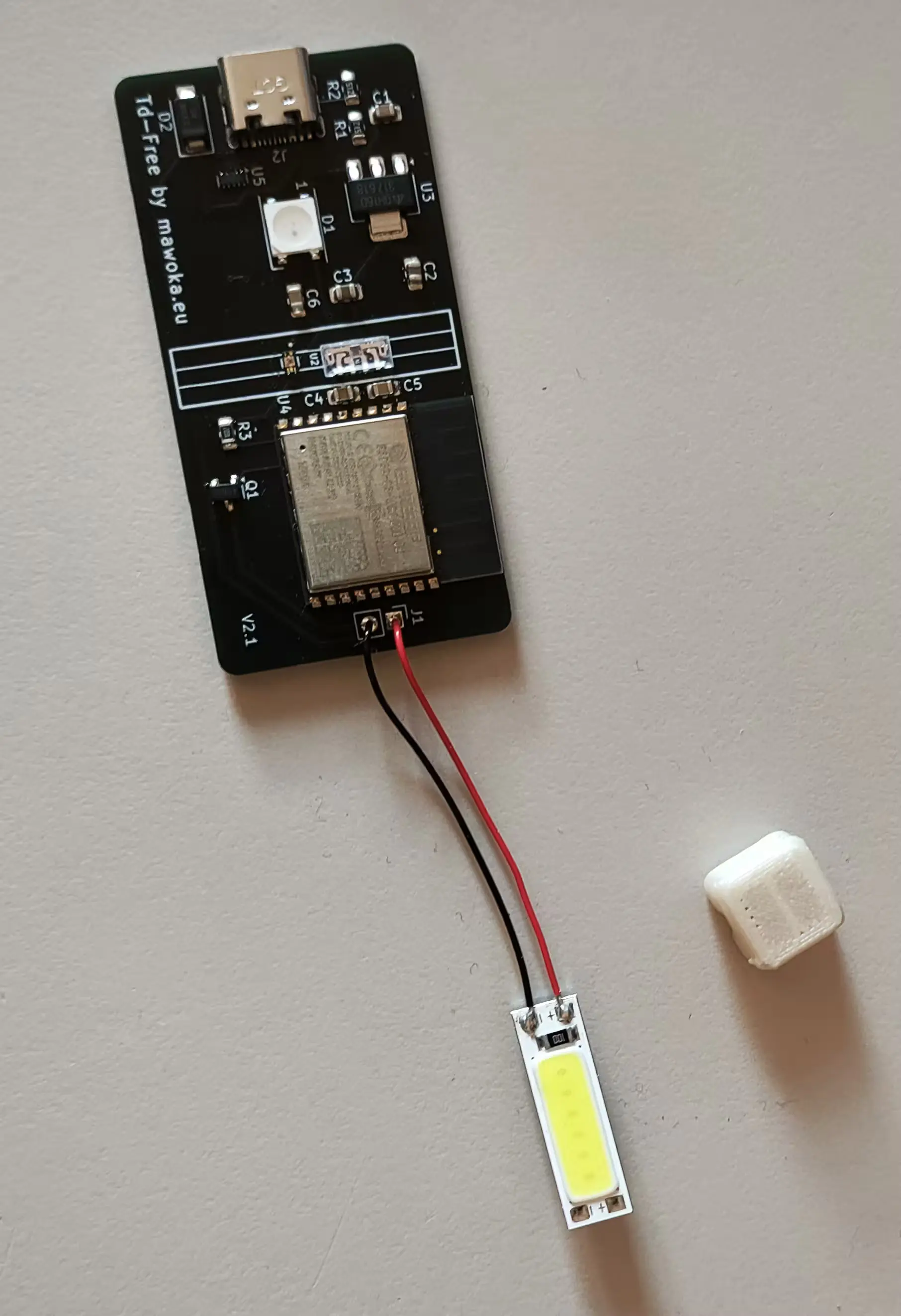 PCB with LED soldered onto it with the aforementioned protector next to it