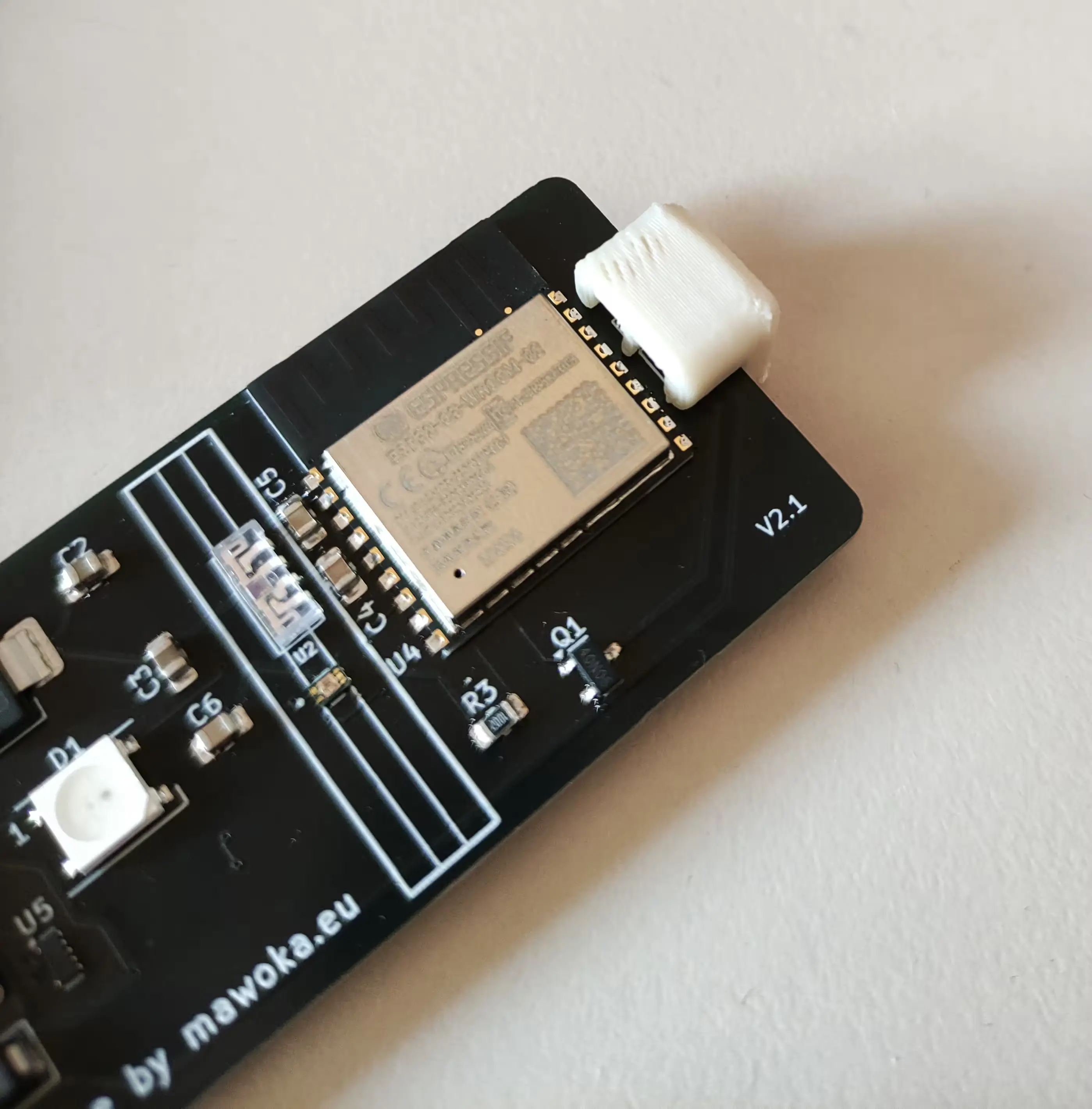 PCB with beige/white cable protector on it